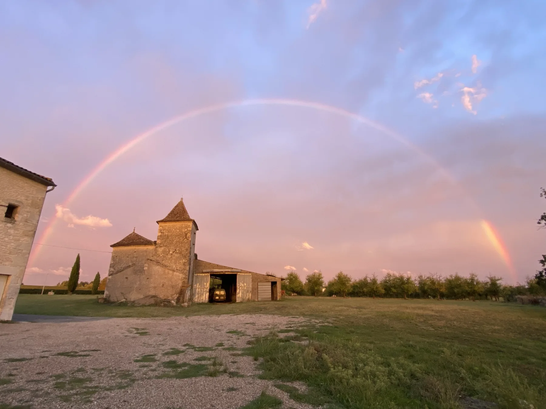 Bâtisse du domaine Le Voisin sous un arc-en-ciel